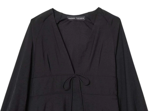 Detail view of the black V-neck dress collar with adjustable tie-up string and label info