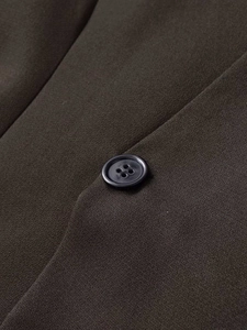 Detail of dark olive blazer fabric texture and classic black button closure