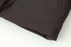 Macro detail of the adjustable drawstring hem on a loose winter puffer jacket