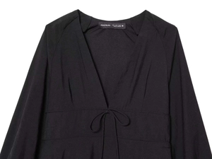 Detailed close-up of V-neck design and adjustable drawstring waist on black dress