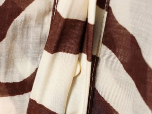 Gros plan du tissu zébré montrant la texture fine et le détail du bouton beige élégant