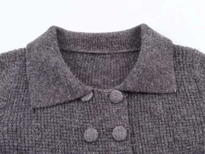 Close-up of dark grey knitted cardigan with lapel collar and double-breasted buttons