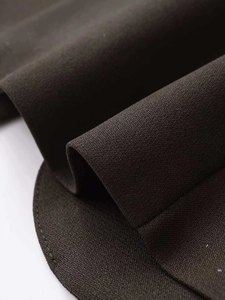 Macro shot of high-quality dark fabric texture and curved hem stitching on blazer
