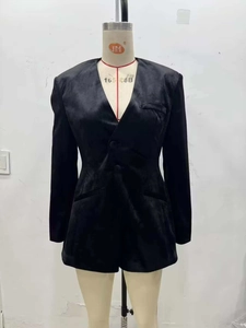 Detailed view of women's black velvet jumpsuit with V-neckline and button closure
