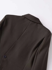 Detailed view of dark brown blazer collar and textured woven fabric with fine twill