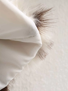 Detailed macro view of the cow print faux fur coat with smooth satin lining and neat stitching