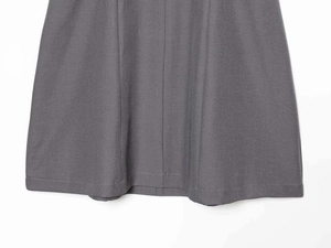 Detailed close-up of grey twill fabric texture and stitching on a deep V-neck dress