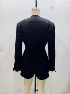 Detail of slim-fit back tailoring and waist stitching on this black long-sleeve jumpsuit
