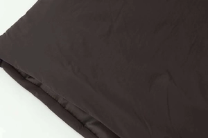 Macro shot of black puffer jacket nylon fabric with side drawstring detailing and filling