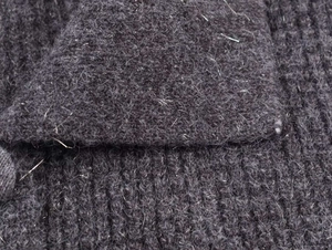 Detailed macro view of charcoal grey knit texture with metallic silver thread and fuzzy wool