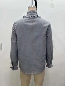 Detailed back view of grey striped shirt with ruffle collar and elastic cuffs on a mannequin