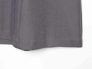 Close-up of charcoal grey dress showing high-quality twill fabric and neat hemline stitching