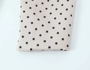 Gros plan macro du tissu à pois sur une veste de blazer beige élégante pour femme