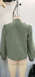 Detail of green and white gingham shirt back with elasticated ruffled cuffs on a mannequin