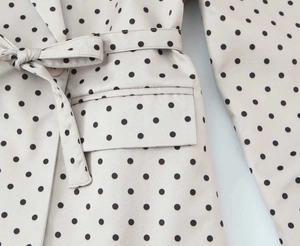 Détail du blazer vintage à pois avec ceinture nouée et poche à rabat sophistiquée