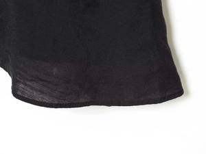 Detail of black V-neck dress fabric with fine texture and neat hemline stitching