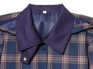 Detalle del cuello de chaqueta a cuadros azul con solapas azul oscuro y botones metálicos
