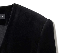 Close-up of black velvet blazer collar and shoulder with premium textured fabric finish
