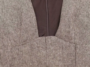 Close-up of brown wool blend tweed fabric texture and invisible zipper detail on dress