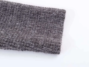 Detailed macro shot showing the dark gray knit texture and soft mohair fibers of the sweater