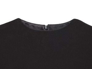 Detail of round neckline with invisible zipper and fine matte black fabric texture