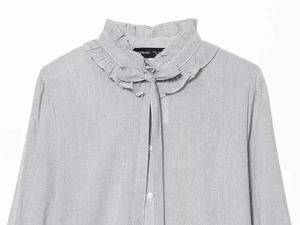 Detailed view of ruffle collar and bow tie on light blue striped long sleeve shirt