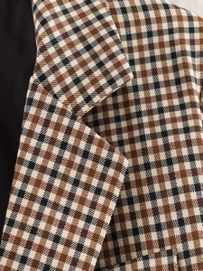 Dettaglio del tessuto scozzese marrone classico con trama a vista e risvolto sartoriale