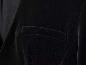 Detail shot of the velvet fabric and fine stitching on the black jumpsuit's pocket