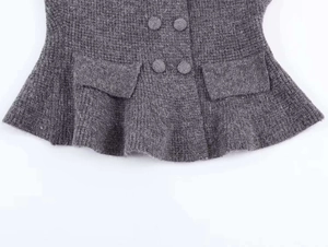 Detailed view of dark grey double-breasted knit cardigan with wool-like texture