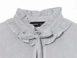 Close-up of ruffled high neck collar and bow tie detail on striped shirt