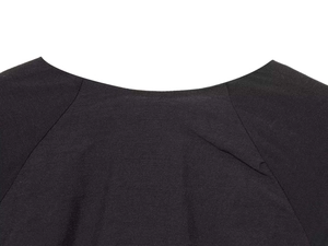 Detail of black V-neck dress showing fine fabric texture and high-quality stitching