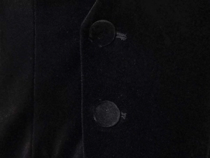 Detailed macro view of black velvet fabric with round fabric-covered buttons and buttonholes