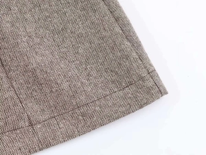 Detail view of the brown wool blend dress hem showing fine knit texture and stitching
