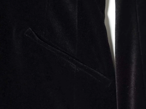 Detailed macro view of black velvet fabric texture and side pocket stitching on the jumpsuit