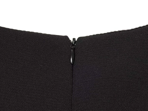 Close-up of the invisible zipper on the back of this black hollow-out cape dress