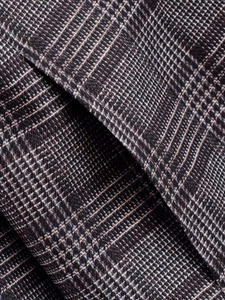 Close-up of Prince of Wales check fabric on a vintage dark grey cropped blazer