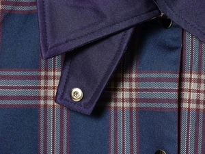 Primer plano del cuello de chaqueta a cuadros vintage con detalle de botón a presión