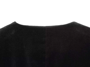 Close-up of the elegant V-neckline on a black velvet jumpsuit with fine stitching