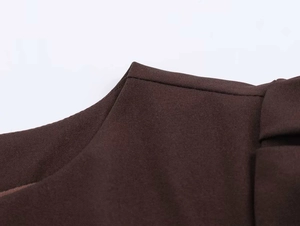 Nahaufnahme des Ausschnitts und der Schulternaht an diesem braunen Faltenkleid