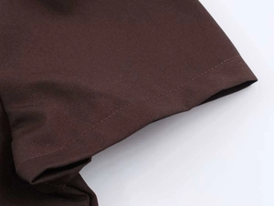 Makroaufnahme der präzisen Nähte und des glatten kaffeebraunen Stoffes am Mini-Kleid