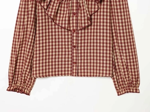Detail of red gingham shirt showing ruffled collar and elastic cuffs with buttons