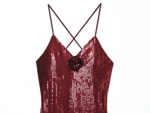 Detail van een bordeauxrode pailletten top met 3D-roos en glanzende metallic afwerking