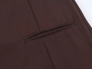 Detailaufnahme einer Paspeltasche auf dunkelbraunem, plissiertem Sommerkleidstoff
