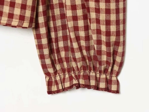 Detailed close-up of red and white gingham sleeve cuff with ruffled elastic edges