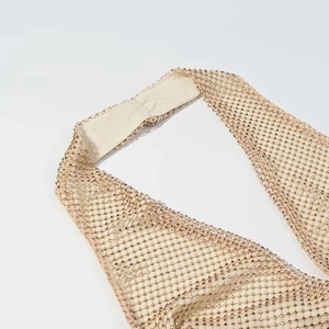 Détail d'une robe dos nu or champagne avec strass scintillants et texture résille