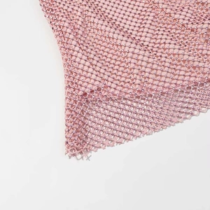 Macro detail of pink mesh fabric featuring shimmering rhinestone grid embellishments