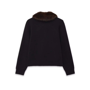 Detail view of the ribbed cuffs and hem on this black knit cardigan with faux fur collar