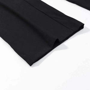 Close-up of black tailored trouser hems with clean stitching and premium fabric texture