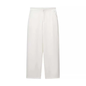Detail of high-waisted white wide-leg trousers with elegant drape and side pockets