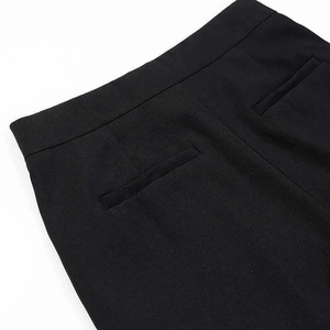 Detailed view of women's black formal trousers featuring rear welt pockets and woven texture